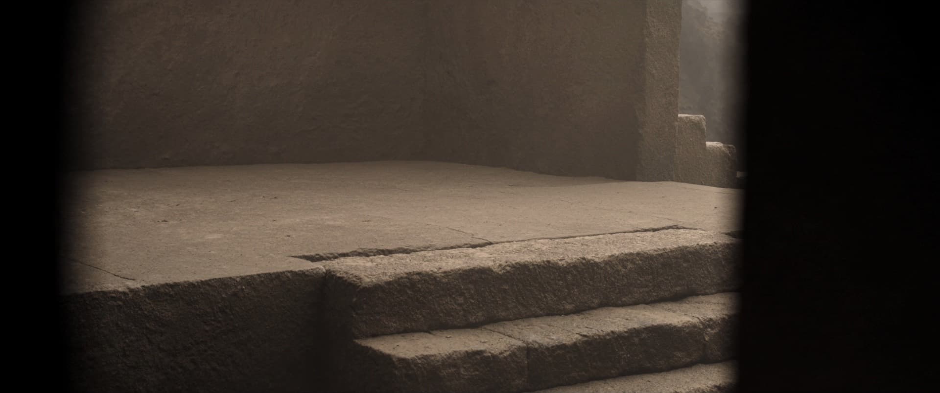A broad stone platform seen through a doorway, lit evenly from every side. Nothing is in shadow and every edge of the stone is legible.